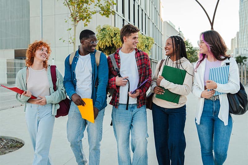 five students walking and talking to each other