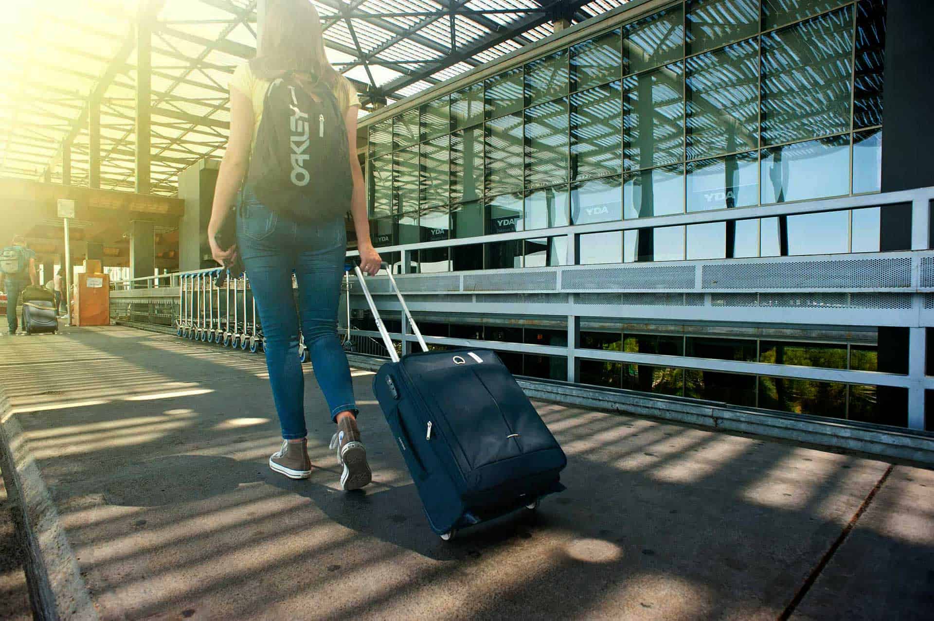 a woman walking with her suitcase at the railway station