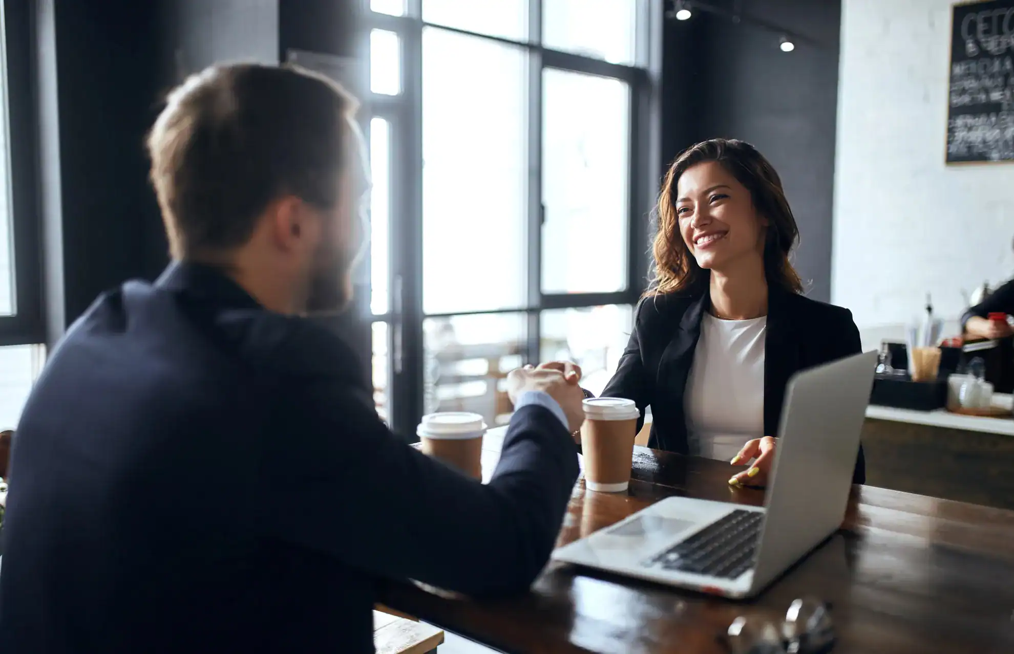 Smiling woman shaking hands with consultant